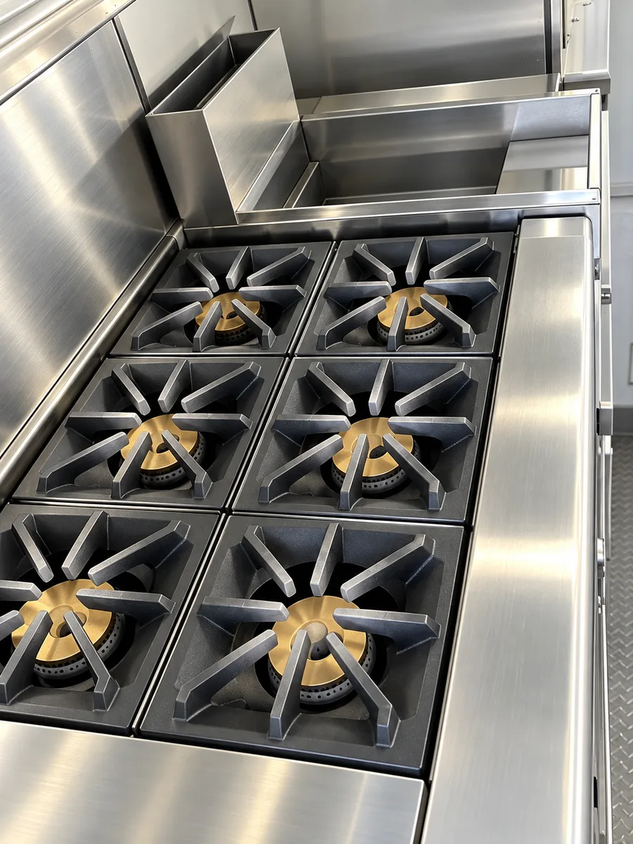 Supplied close view of a commercial six-burner range.