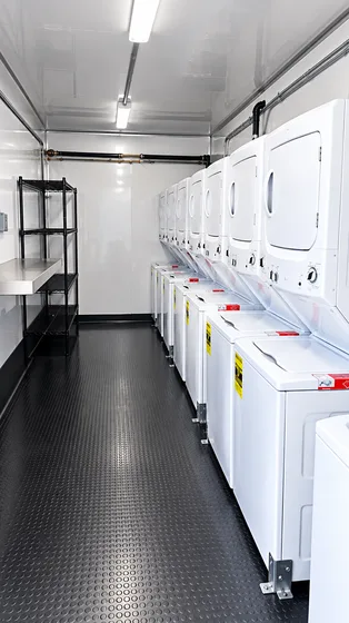 Supplied reference image labelled mobile laundry trailer washer dryer interior.
