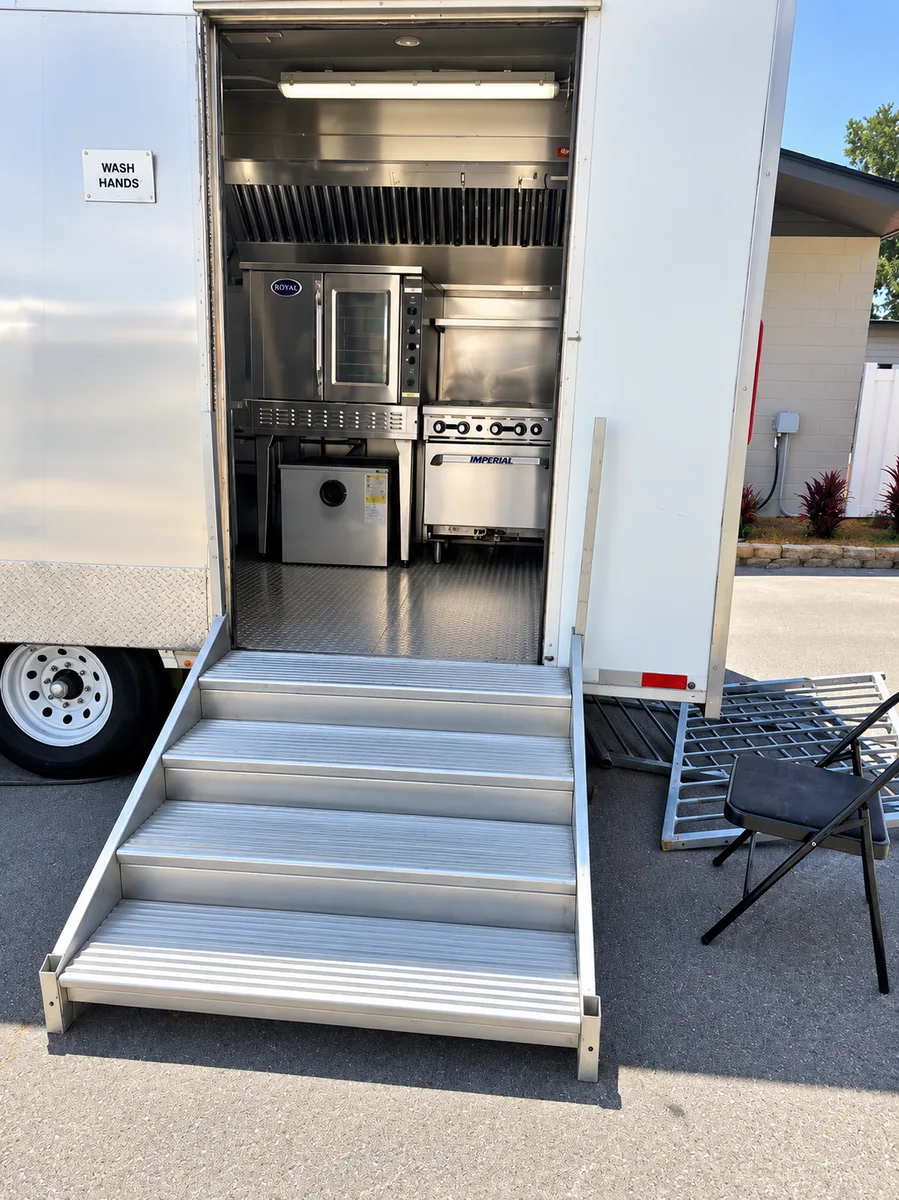 Supplied mobile commercial kitchen trailer with its service entry open