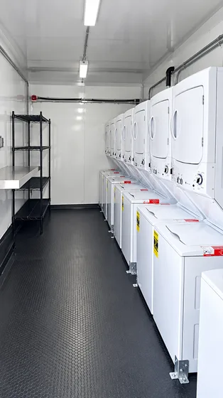 Supplied reference image labelled mobile laundry trailer commercial washers dryers.