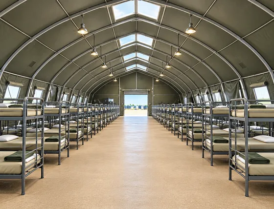 Supplied reference image labelled temporary sleeping facilities large bunkhouse interior.